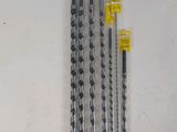 four pieces of drill bits sitting on top of a table