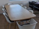 une table et des chaises dans une pièce donnant sur un champ