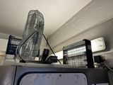 a fan sitting on top of a refrigerator in a kitchen