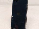a black iphone sitting on a stand on a white surface