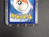 a pokemon card in a plastic case on a table