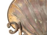 a metal object that is on a stand on a white surface