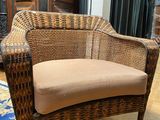 a wicker chair that is sitting on a hard wood floor