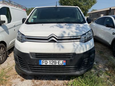 une camionnette blanche garée à côté d'autres voitures