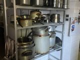 de nombreuses casseroles et poêles sur les étagères de la cuisine