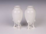 deux vases blancs posés l'un à côté de l'autre sur une table
