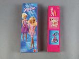 two barbie dolls are sitting next to each other on a table