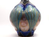 a blue and gold vase sitting on a white surface