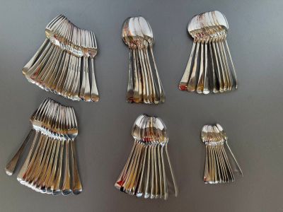 several spoons and forks are arranged in a row on a table