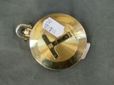 a gold pocket watch that has a tag on it