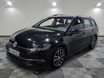 La Volkswagen Golf break noire est garée dans une grande pièce au sol carrelé.