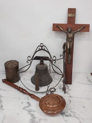 une croix, une cloche et un crucifix en bois posés sur une table