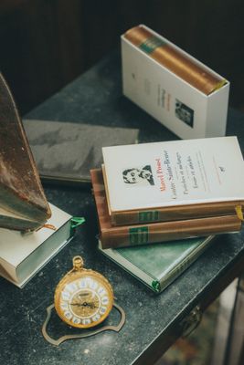 une petite table sur laquelle se trouvent des livres et une horloge