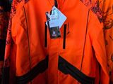 une veste orange accrochée à un portemanteau dans un magasin