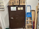 des cartons empilés sur un réfrigérateur dans une pièce où se trouve une échelle