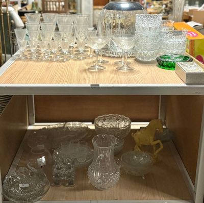 many glasses and vases on a shelf in a store