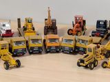plein de petits engins de chantier en jouets posés sur une table