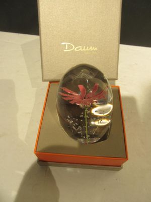 un vase en verre avec une fleur à l'intérieur sur une table