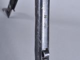 a close up of a gun on a table with a gray background