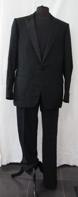 a black suit on a mannequin stand against a white backdrop
