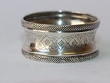 gros plan d'une bague en argent sur une surface blanche