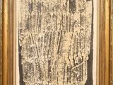 une peinture en noir et blanc représentant une plante, dans un cadre doré