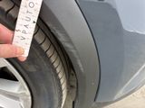 a person holding a measuring tape on the rim of a car