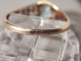 a gold ring sitting on top of a clear piece of glass