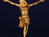 a gold statue of jesus on the cross on a blue background