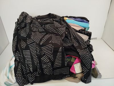 a pile of clothes sitting on top of a white shelf