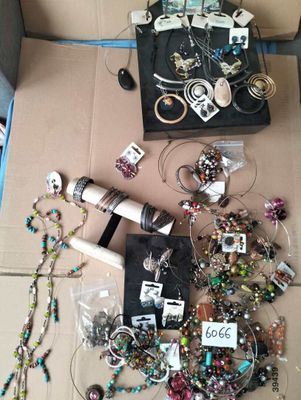a box full of assorted jewelry and accessories on the floor