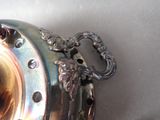 a silver tea pot with a handle on a table