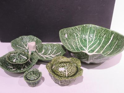 a bowl, bowl, plate, and bowl with cabbage leaves on it