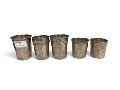 four metal cups sitting next to each other on a white surface