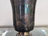 un vase en argent posé sur une table en verre