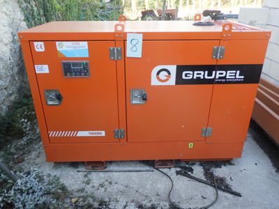un gros plan d'un petit générateur orange posé sur un sol en béton