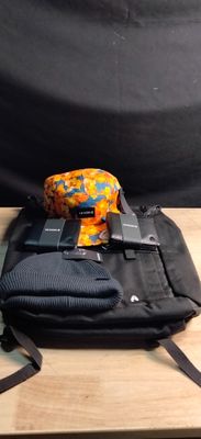 a black bag with a camera and a cell phone on it