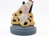 the figurine is sitting on top of a piece of cheese