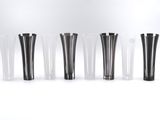 six vases noirs et blancs alignés sur une surface blanche