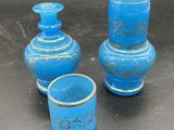 trois vases bleus posés les uns à côté des autres sur une table