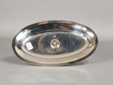 an oval silver plate with a diamond in the center