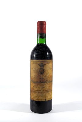 une vieille bouteille de vin posée sur une surface blanche
