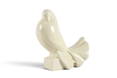 une figurine d'oiseau blanc posée sur un bloc