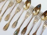 a lot of silver spoons and forks on the table