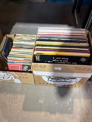 beaucoup de disques dans une boîte posée par terre