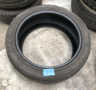 Plusieurs pneus sont alignés sur un sol en béton dans un garage