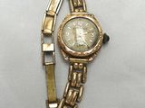 an image of a gold wrist watch with roman numerals on it