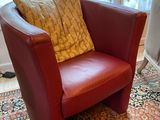 un fauteuil rouge avec un coussin jaune dans un salon