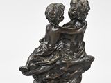 bronze sculpture of two children sitting on a rock