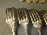 five forks and five spoons on a table